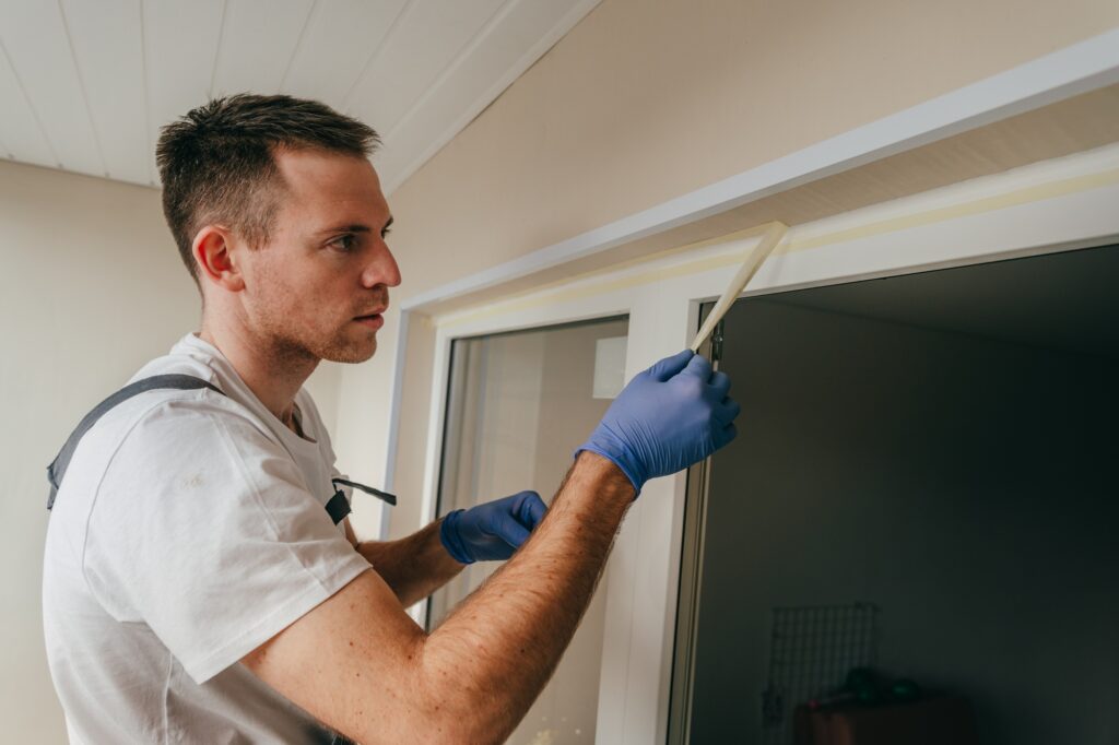 Young man using waterproof silicone and spatula